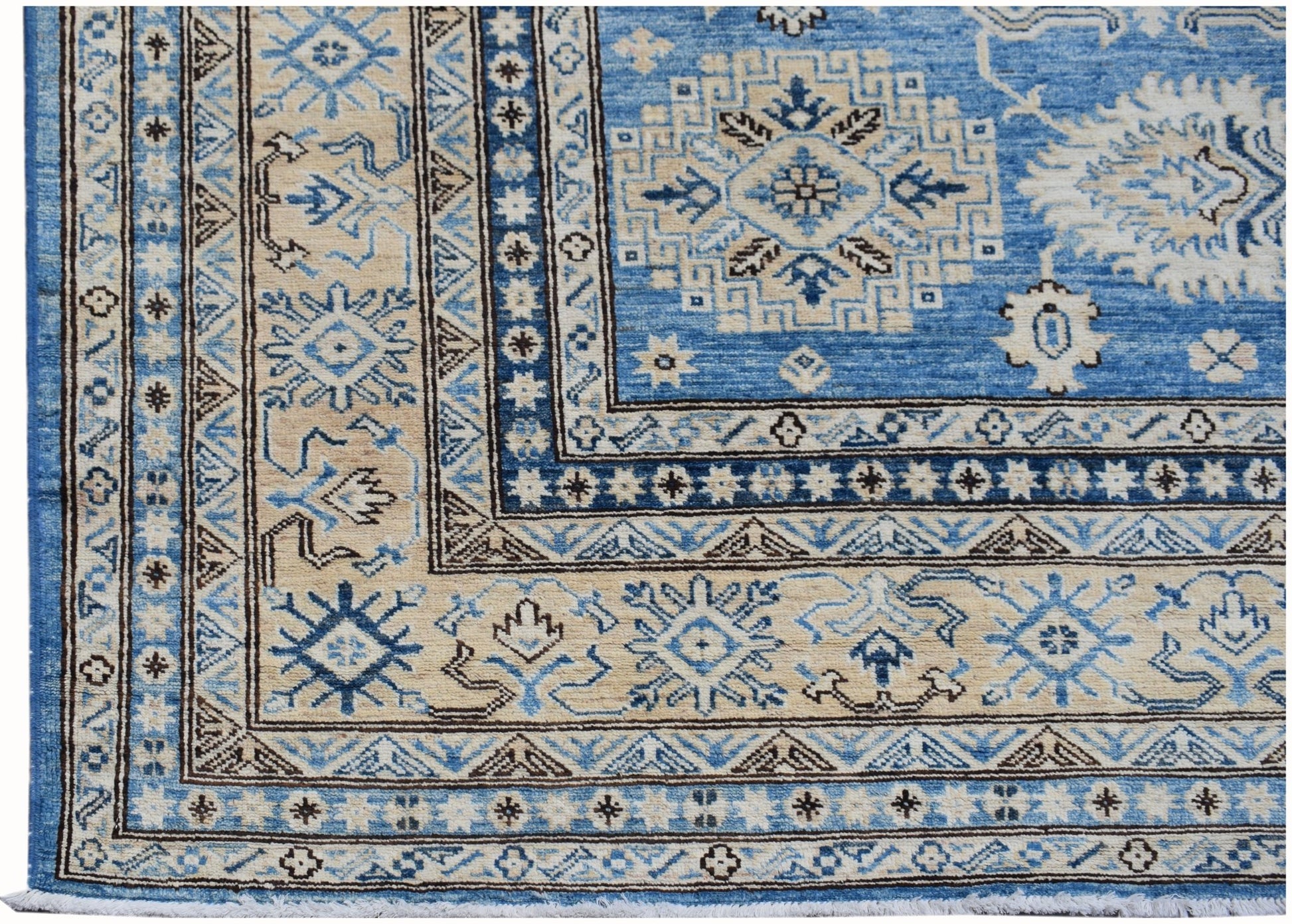A handmade Afghan Super Kazakh rug featuring traditional geometric motifs in blue and beige.