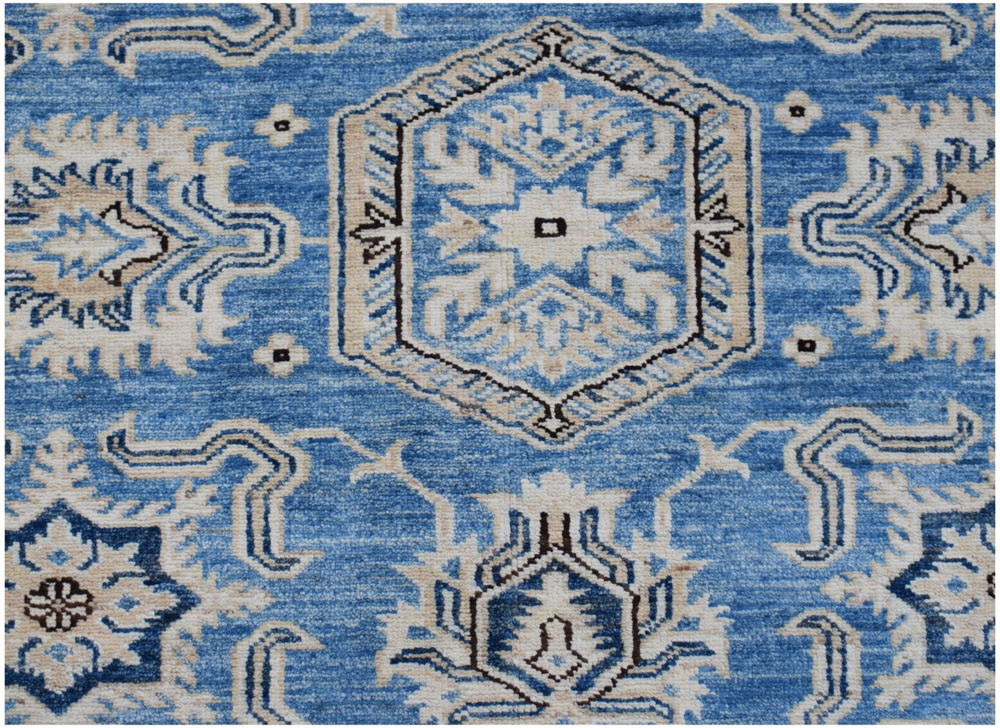 An Afghan Super Kazakh rug featuring traditional geometric motifs in shades of blue and cream.
