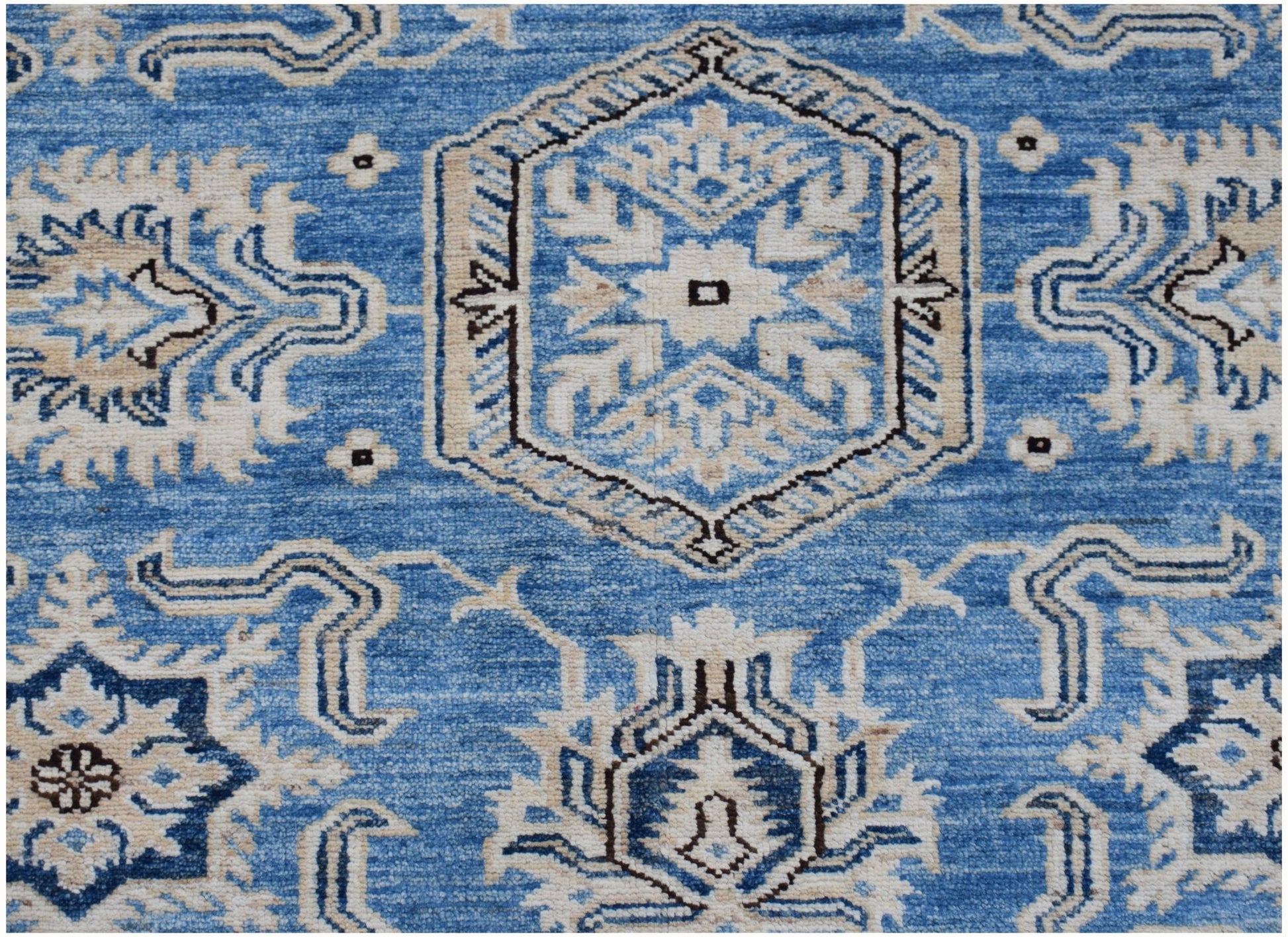 An Afghan Super Kazakh rug featuring traditional geometric motifs in shades of blue and cream.