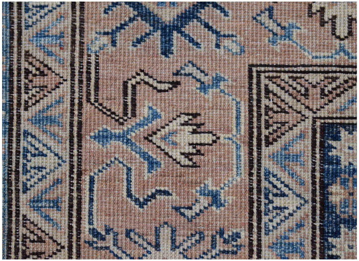 A close-up of an Afghan Super Kazakh rug featuring traditional geometric motifs in blue and beige.