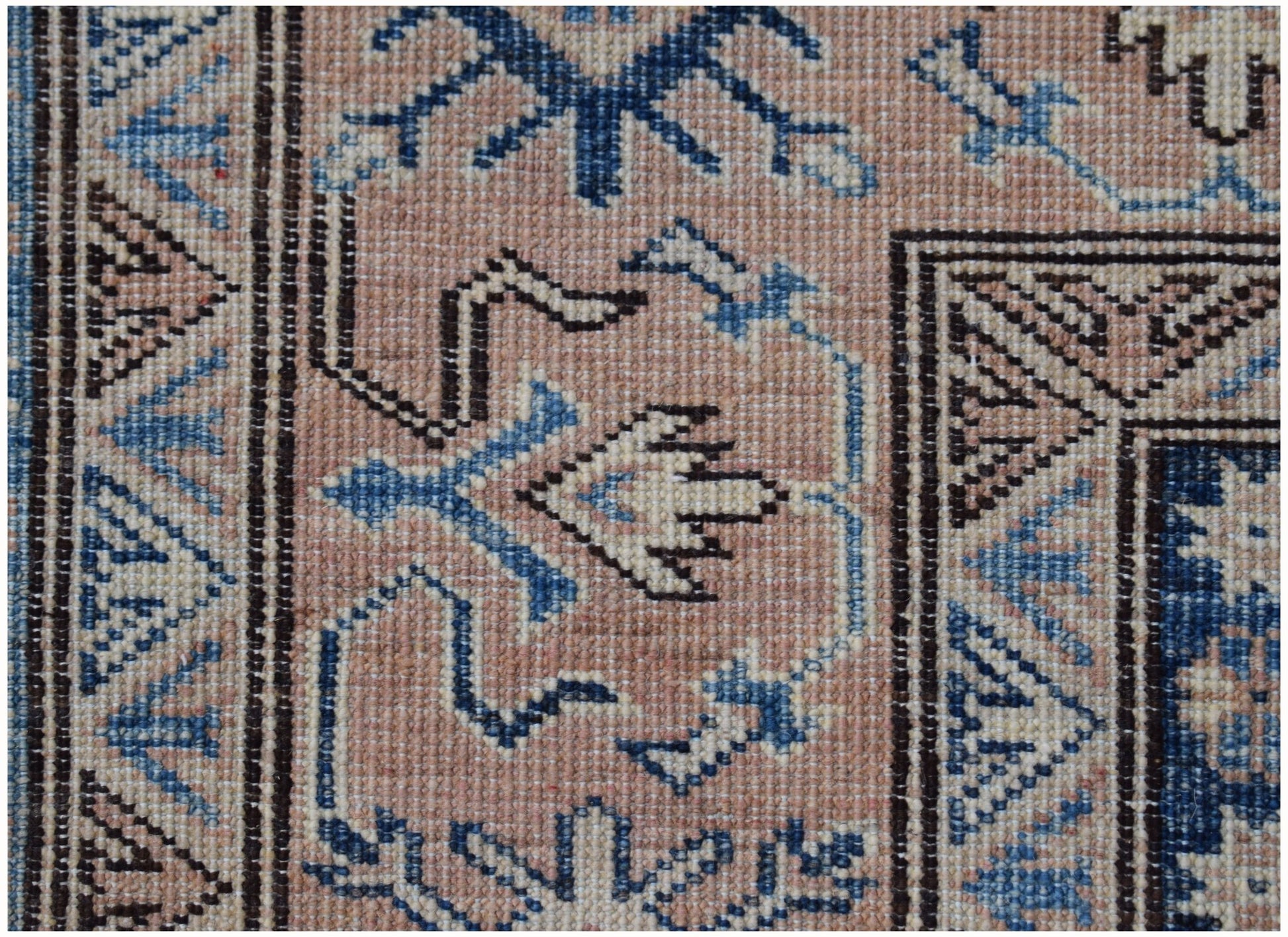 A close-up of an Afghan Super Kazakh rug featuring traditional geometric motifs in blue and beige.