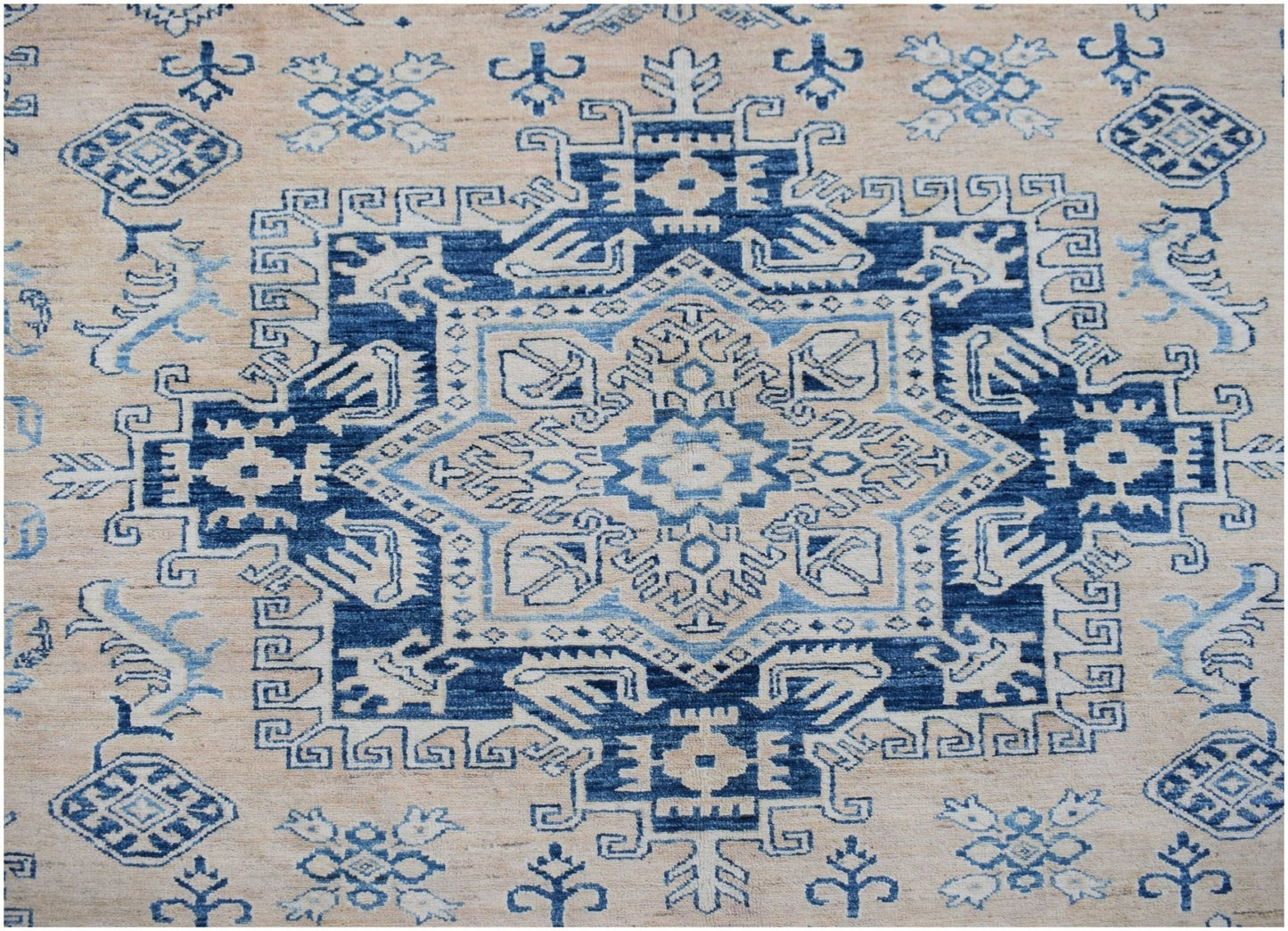Handmade Afghan Super Kazakh rug featuring a geometric blue and cream medallion pattern.