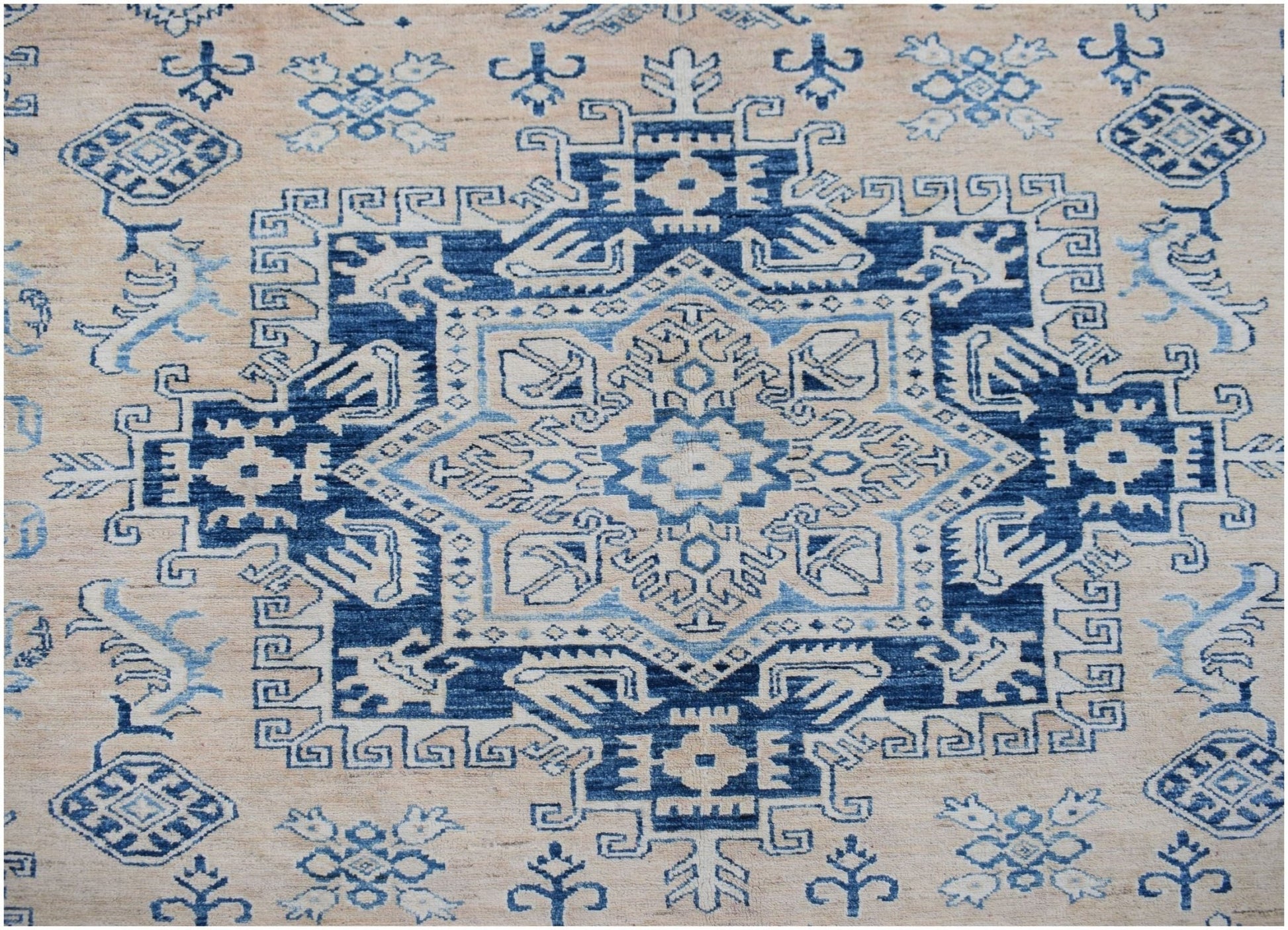 Handmade Afghan Super Kazakh rug featuring a geometric blue and cream medallion pattern.