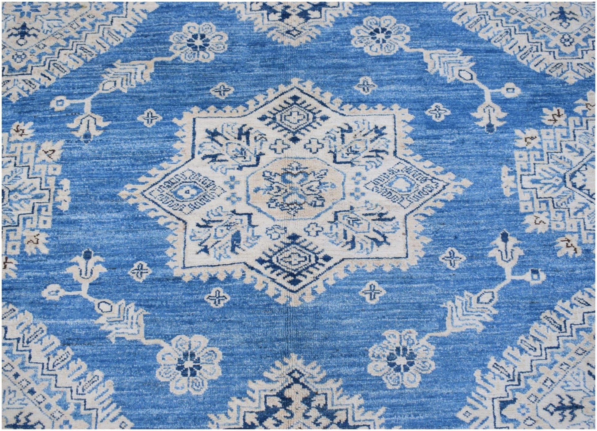 A handmade Afghan Super Kazakh rug featuring a central star medallion in blue and cream wool.