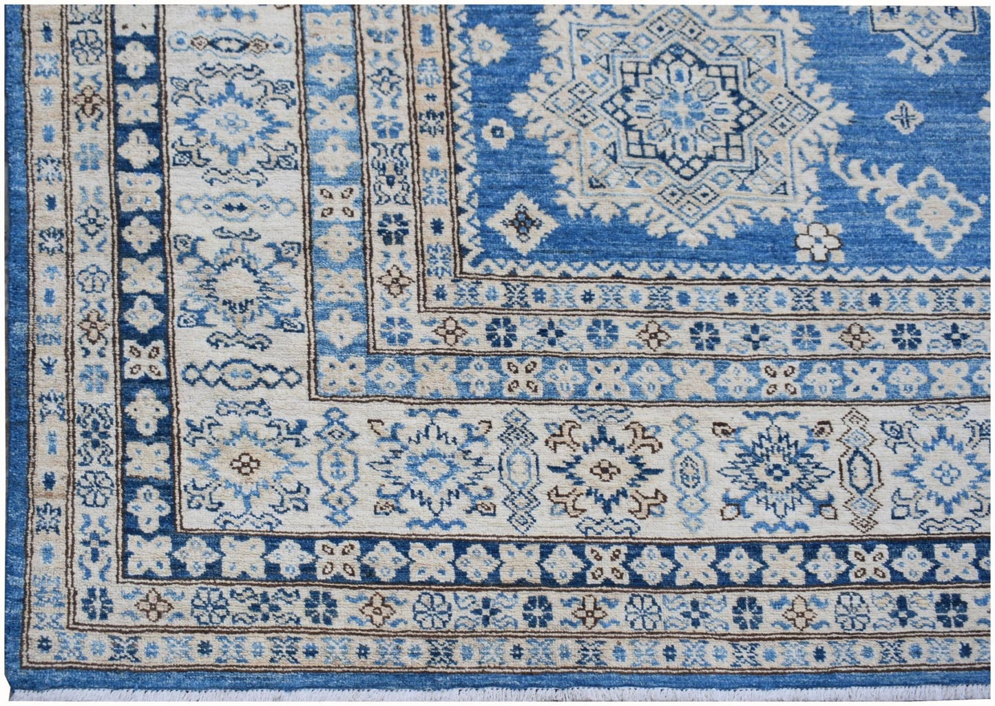 A handmade Afghan Super Kazakh rug featuring traditional blue and cream geometric patterns.