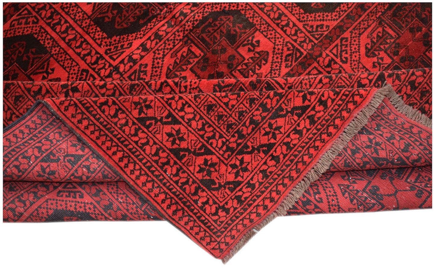 A vintage Afghan Turkmen rug featuring a geometric red and black pattern with visible fringe.