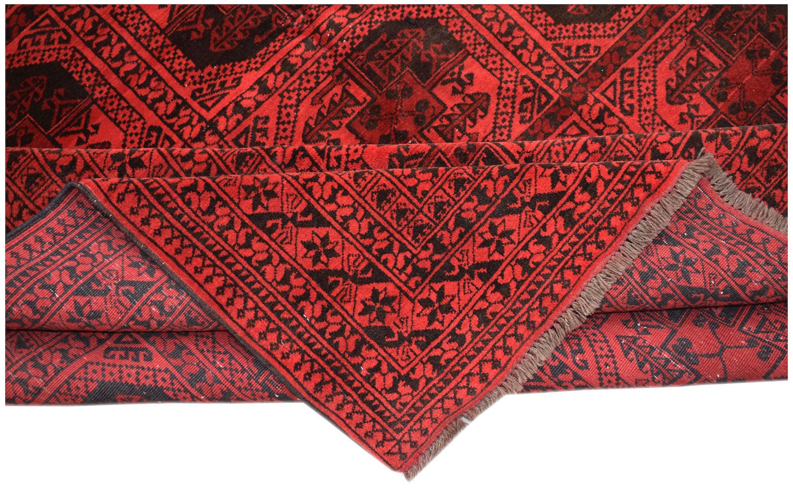 A vintage Afghan Turkmen rug featuring a geometric red and black pattern with visible fringe.