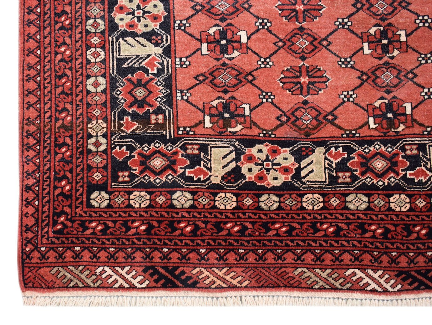 A vintage handmade Afghan Turkmen rug featuring a geometric elephant foot motif in red and black.