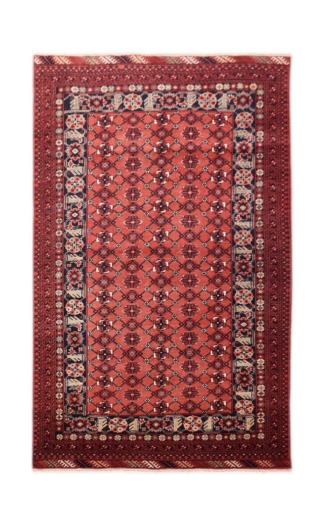 A vintage Afghan Turkmen rug featuring a red field with repeating geometric elephant foot motifs.