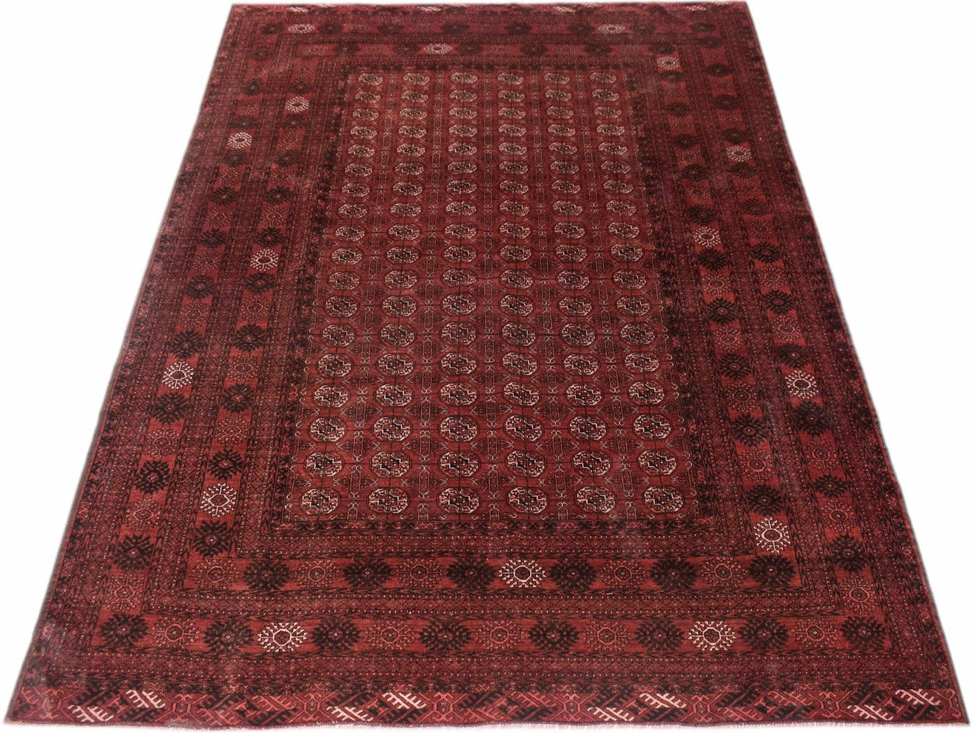 A vintage handmade Afghan Turkmen rug featuring a repeating red and black elephant foot motif.