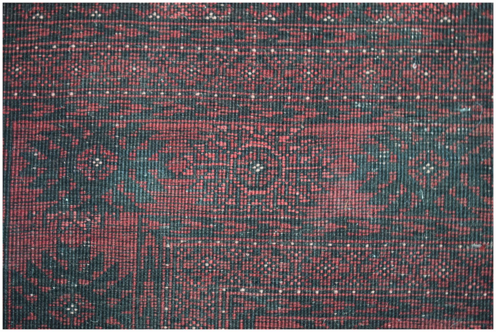A vintage handmade Afghan Turkmen wool rug featuring a traditional red and black geometric pattern.