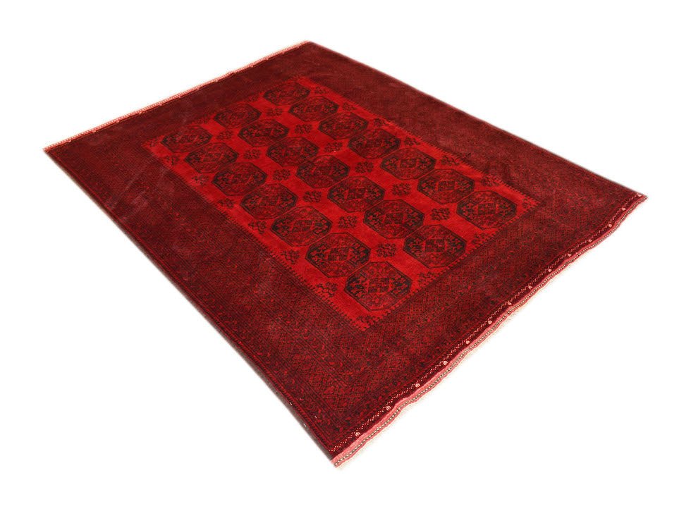 A vintage handmade Afghan Turkmen rug featuring a repeating octagonal pattern in deep red tones.