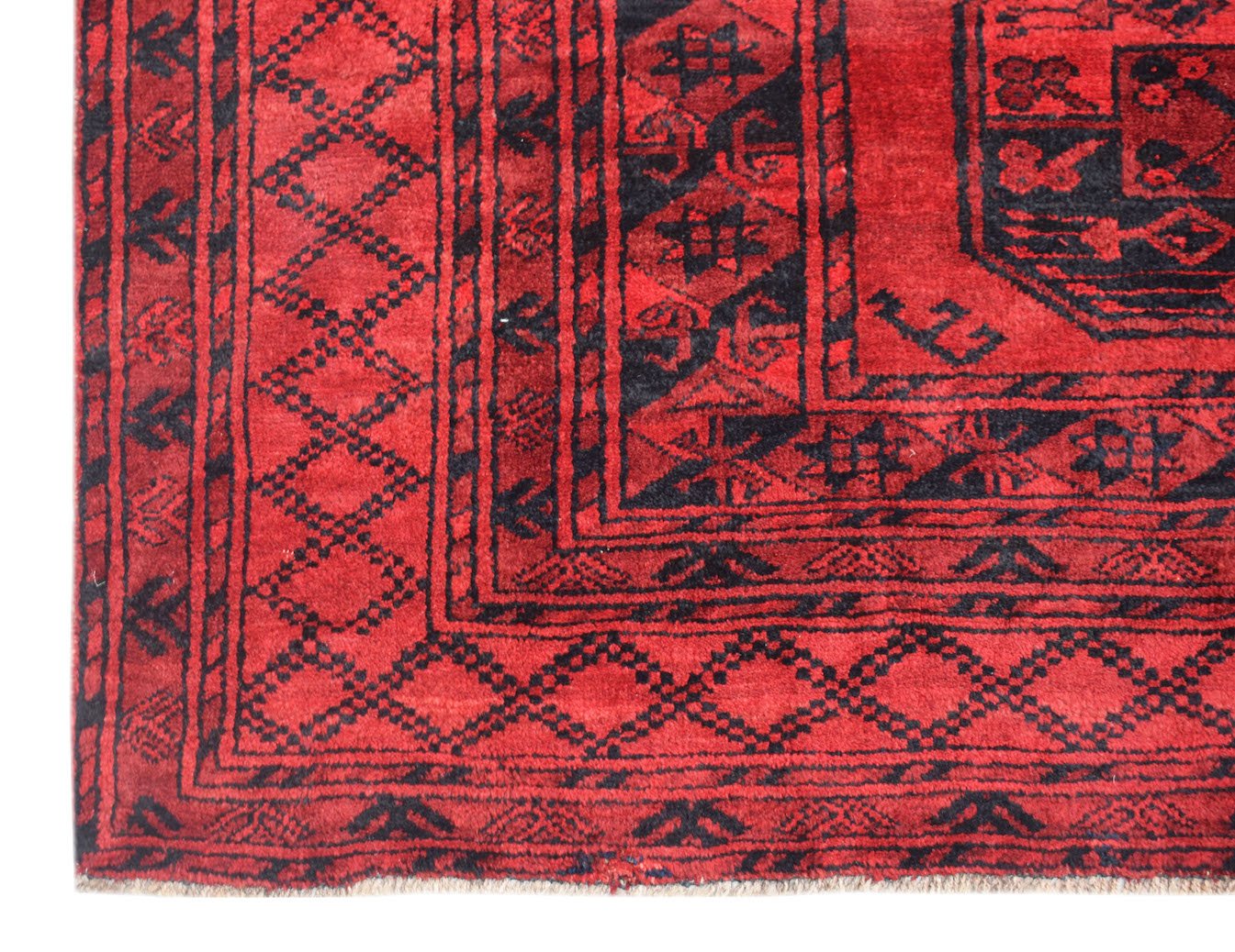 A vintage Afghan Turkmen rug featuring a geometric elephant foot motif in red and black wool.