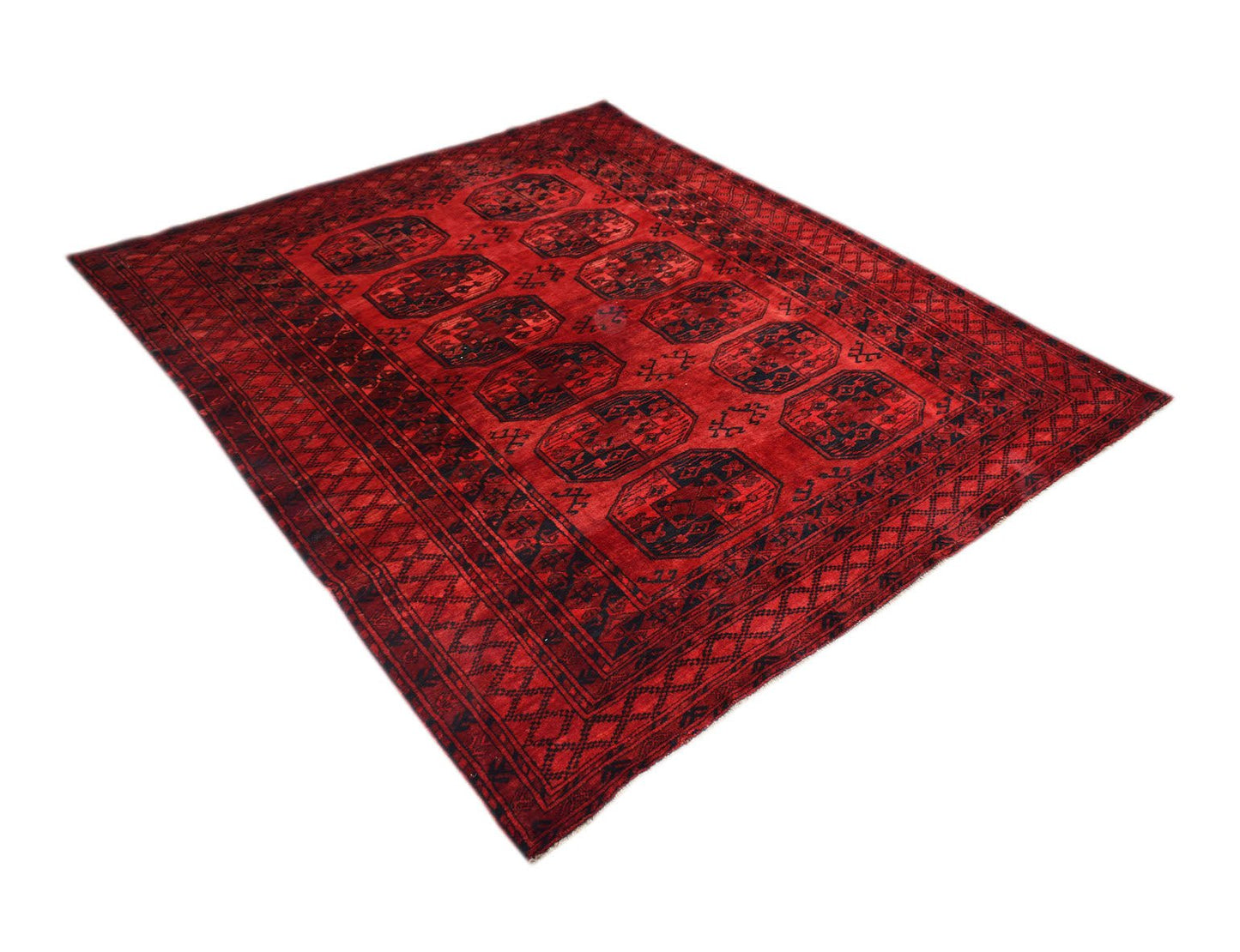 A vintage handmade Afghan Turkmen rug featuring a deep red field with repeating elephant foot motifs.