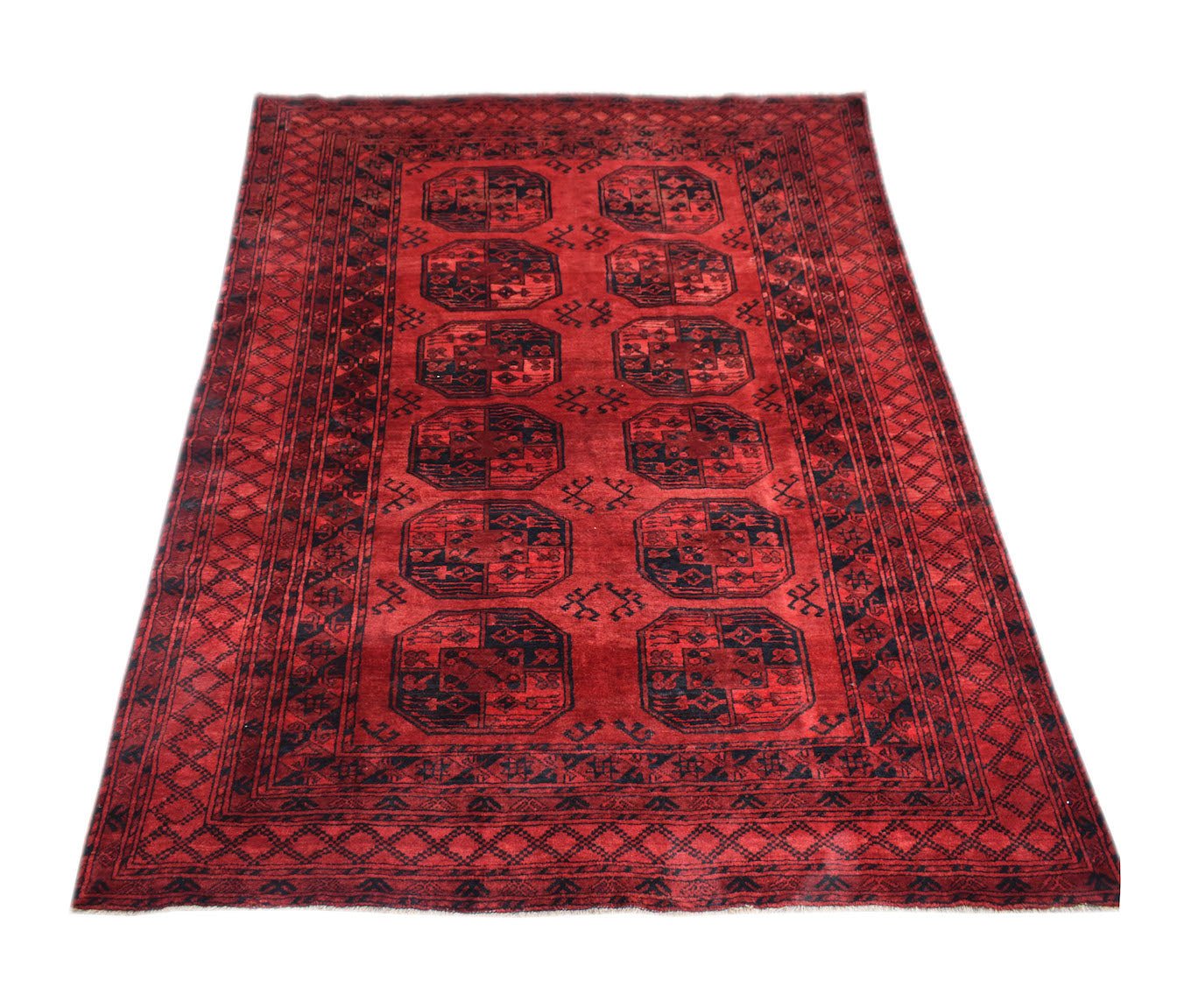A vintage handmade Afghan Turkmen rug featuring a red field with repeating elephant foot motifs.