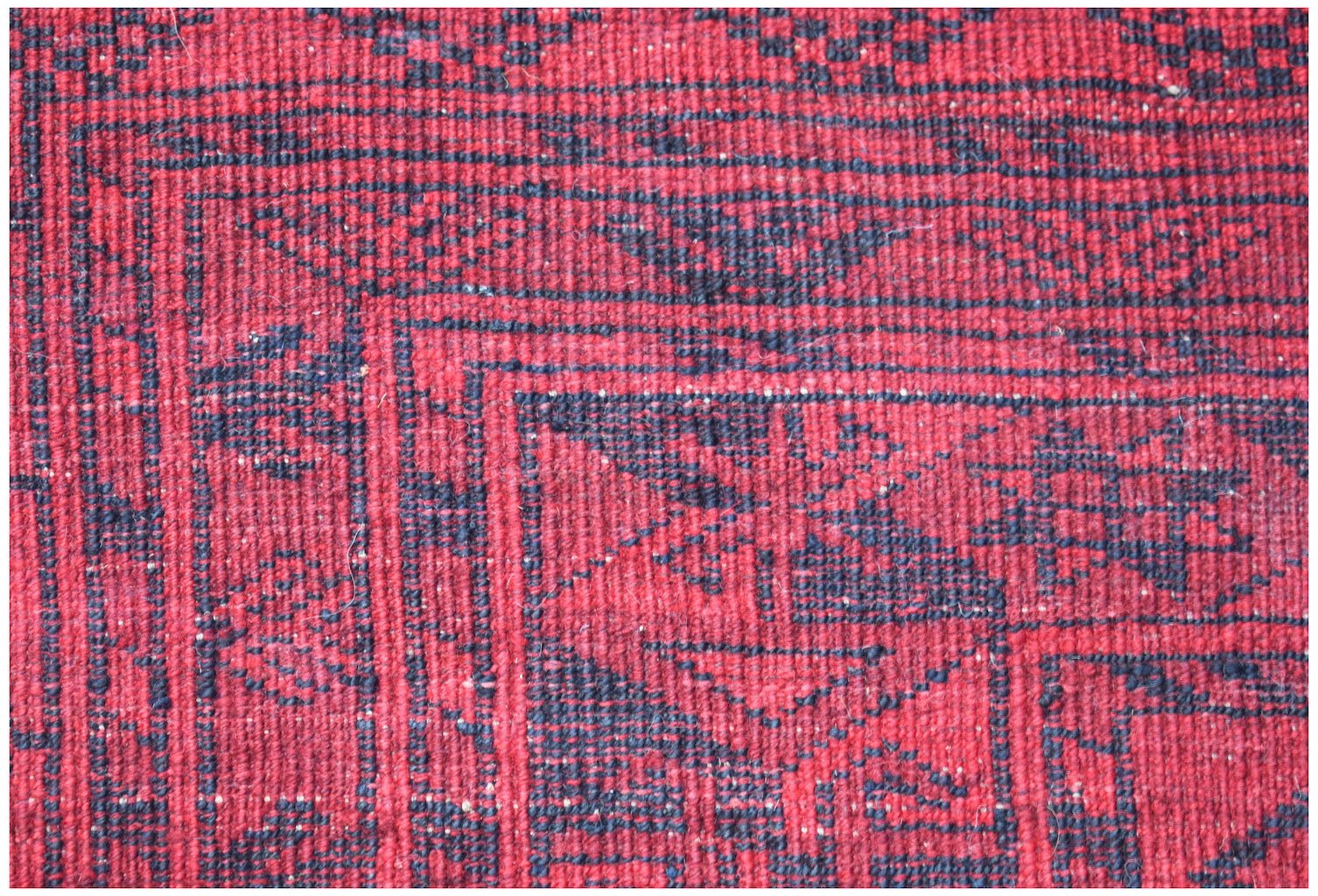 Vintage Afghan Turkmen rug with red and navy geometric patterns.