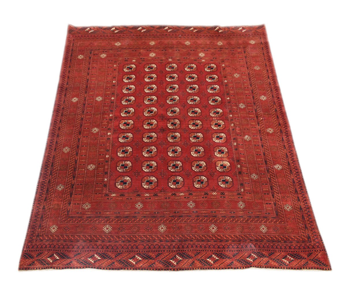 A vintage handmade Afghan Turkmen rug featuring a red field with repeating elephant foot motifs.