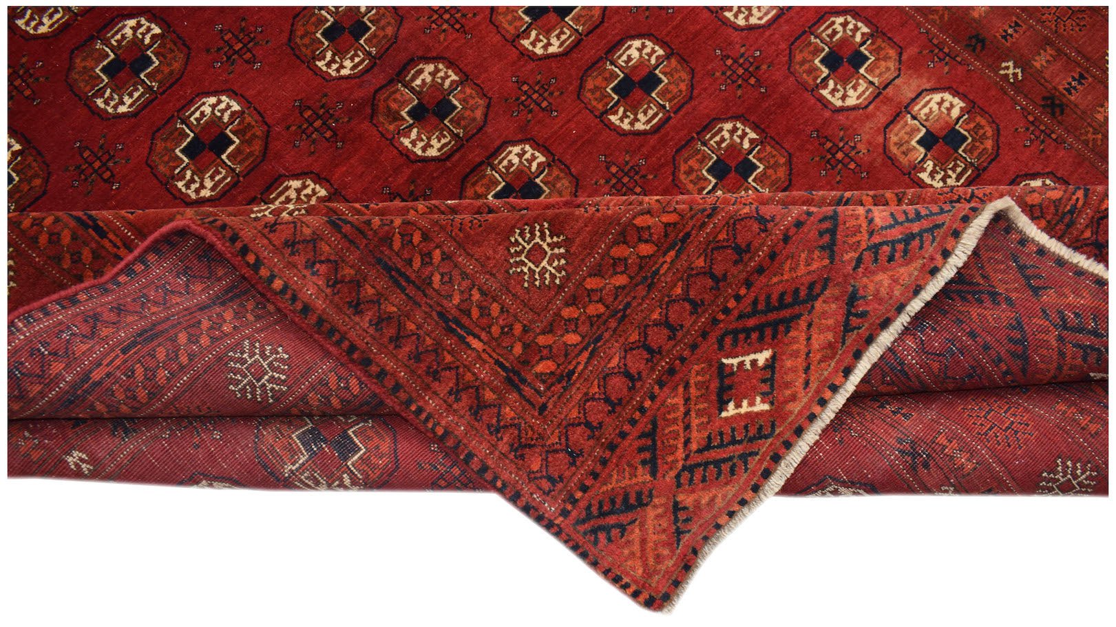 A vintage handmade Afghan Turkmen rug featuring a red field with repeating elephant foot motifs.