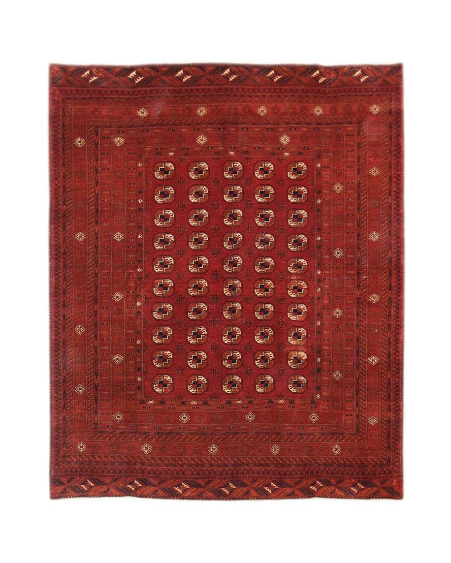 A vintage Afghan Turkmen rug featuring a repeating elephant foot motif in deep red wool.