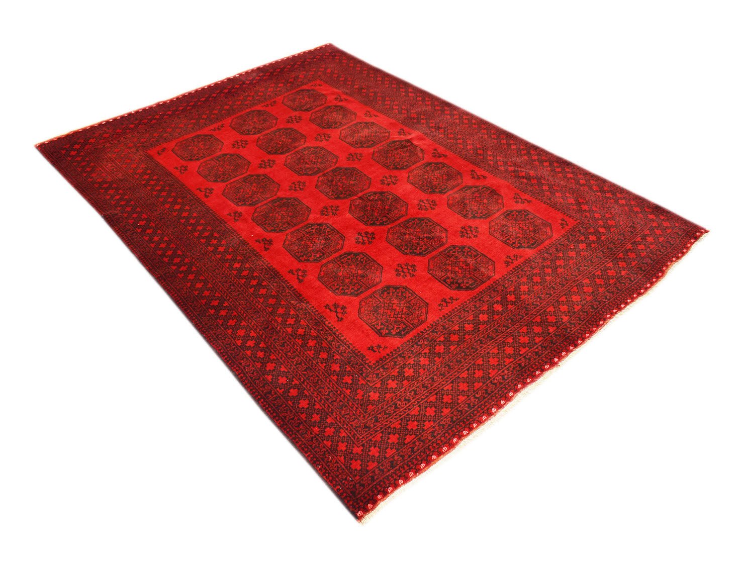 A vintage handmade Afghan Turkmen rug featuring a repeating red and black elephant foot motif.