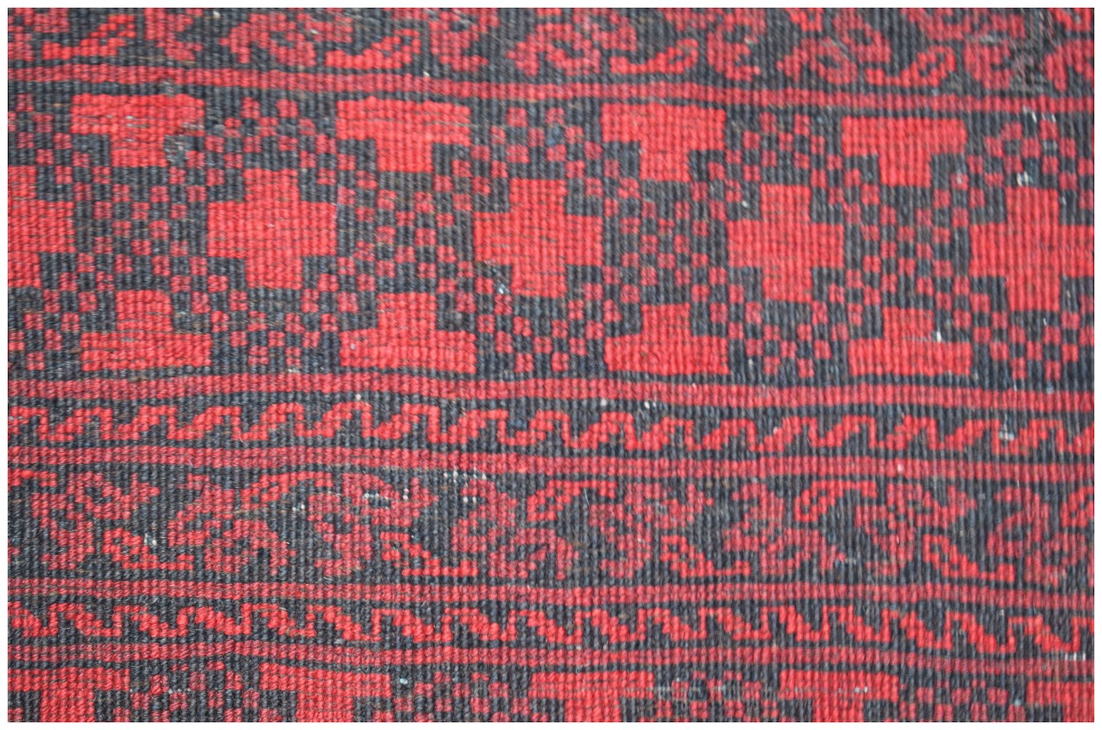 Vintage Afghan Turkmen rug with red and black geometric patterns.
