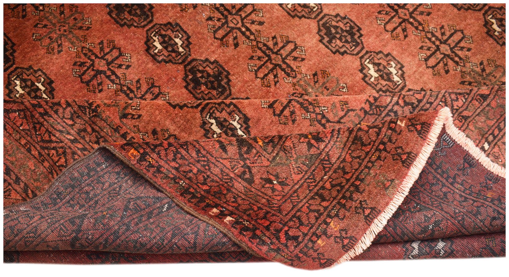 A vintage handmade Afghan Turkmen wool rug featuring a repeating geometric elephant foot motif.