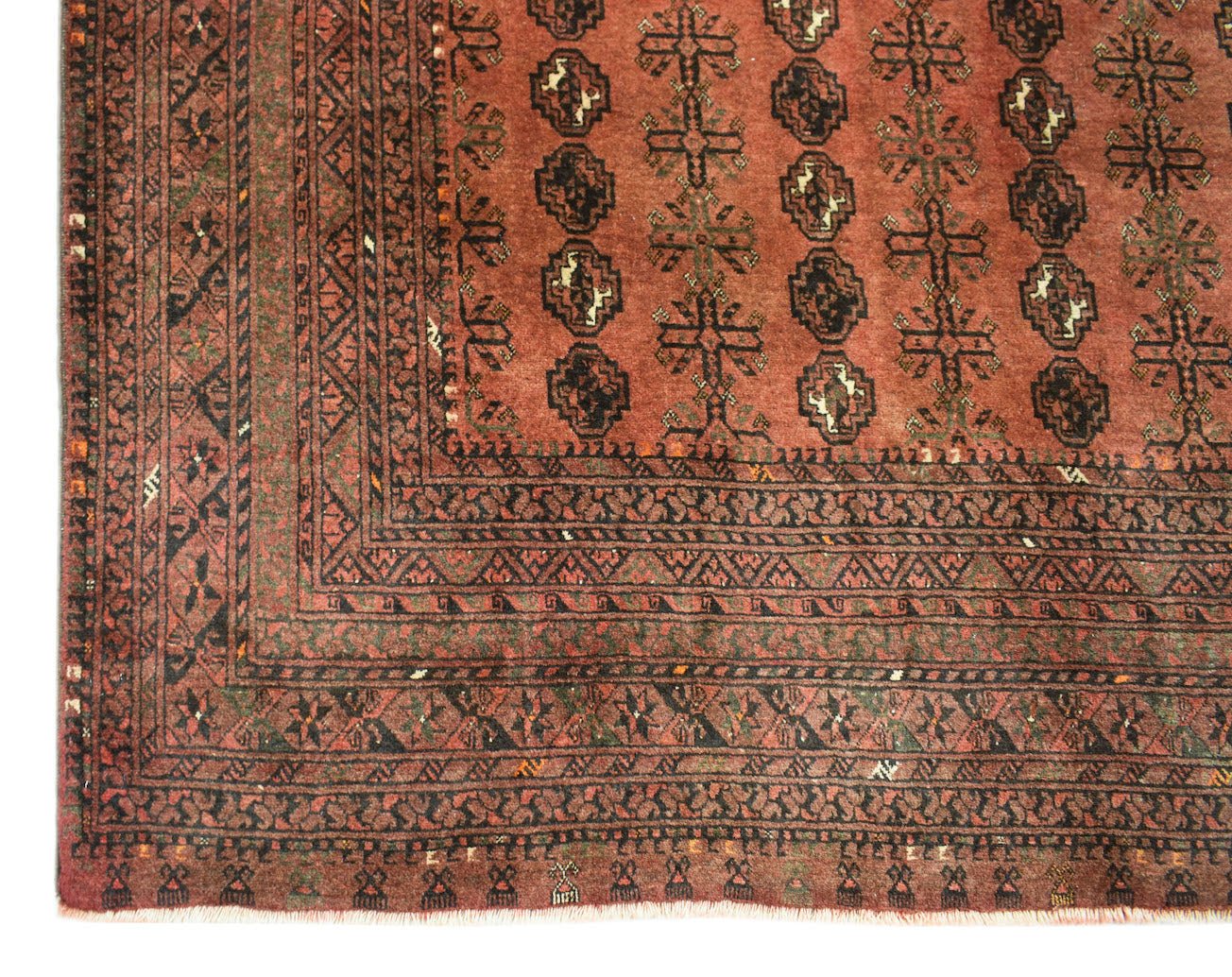 A vintage Afghan Turkmen rug featuring geometric elephant foot motifs in shades of red and black.