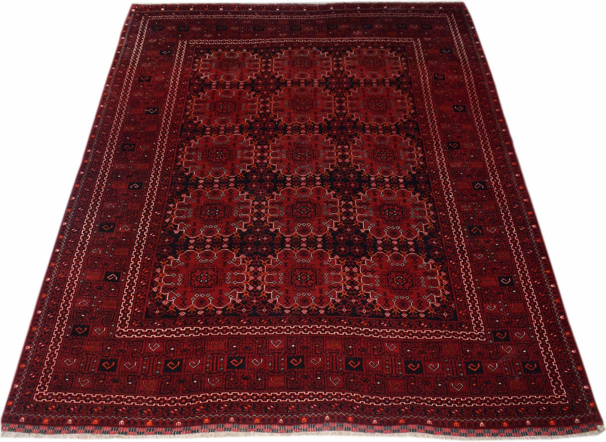 A vintage handmade Afghan Turkmen rug featuring a repeating red elephant foot motif.