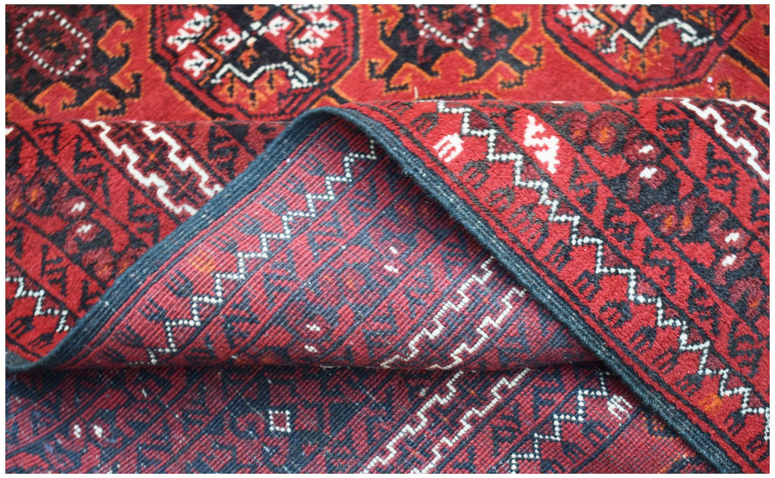 Vintage Afghan Turkmen rug with red, black, and white geometric patterns.