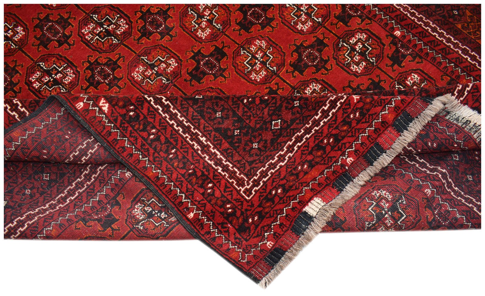 A vintage Afghan Turkmen rug featuring a red field with repeating geometric elephant foot motifs.