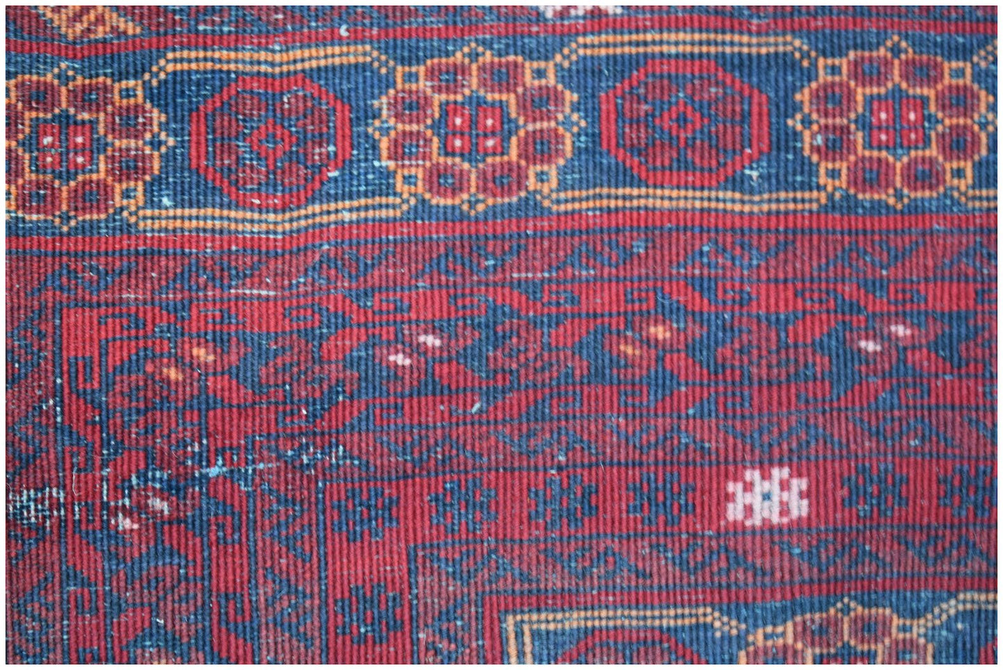A vintage Afghan Turkmen rug featuring a traditional red and blue geometric elephant foot pattern.