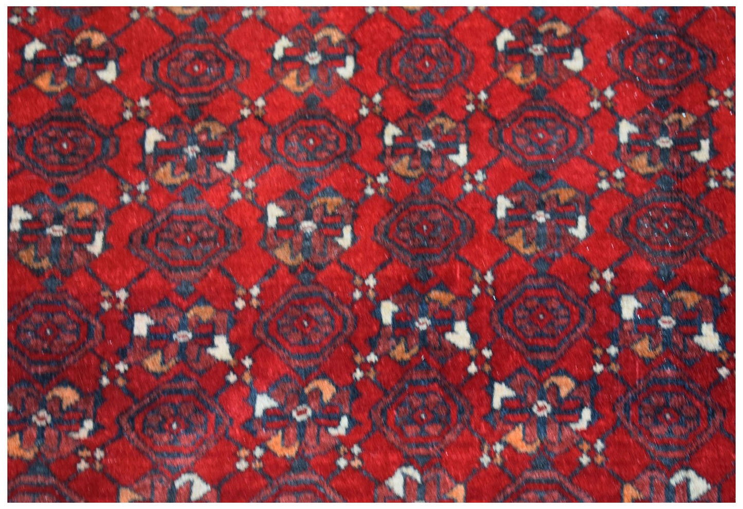 Vintage Afghan Turkmen rug with a red background and geometric patterns.