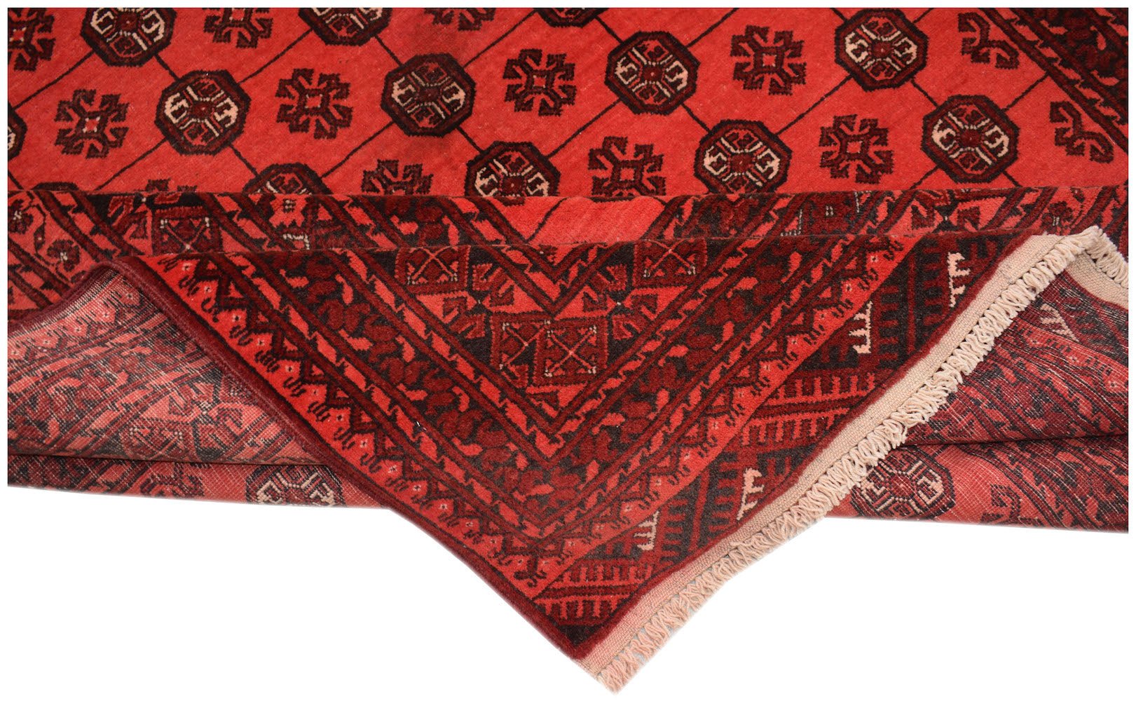 A vintage Afghan Turkmen rug featuring a red field with repeating geometric elephant foot motifs.