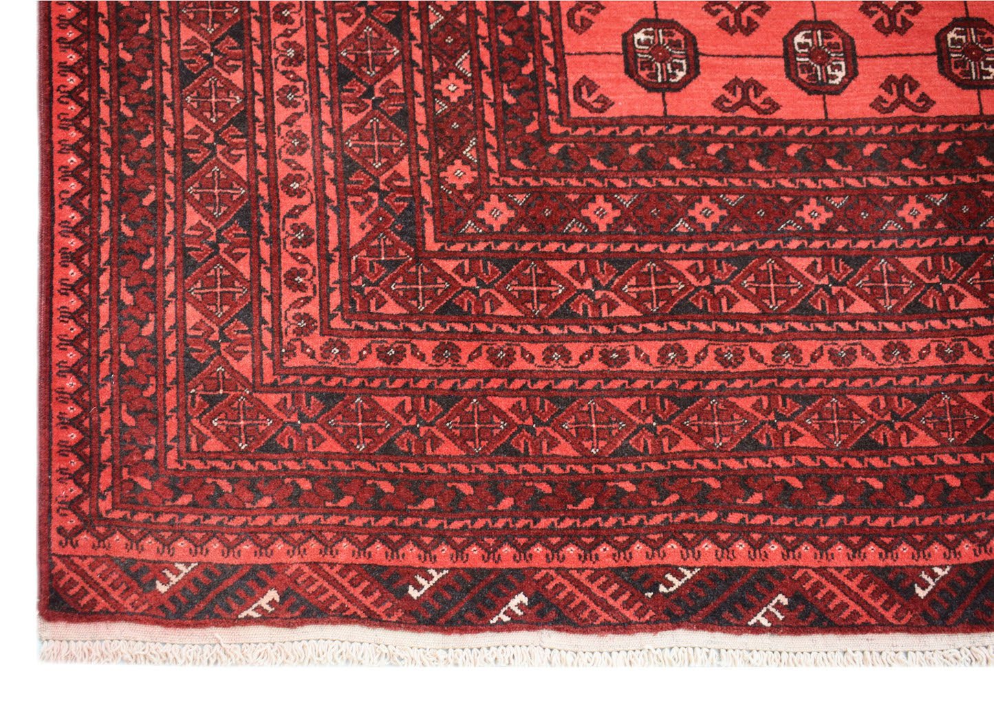 A vintage Afghan Turkmen rug featuring a geometric elephant foot motif in shades of red and black.