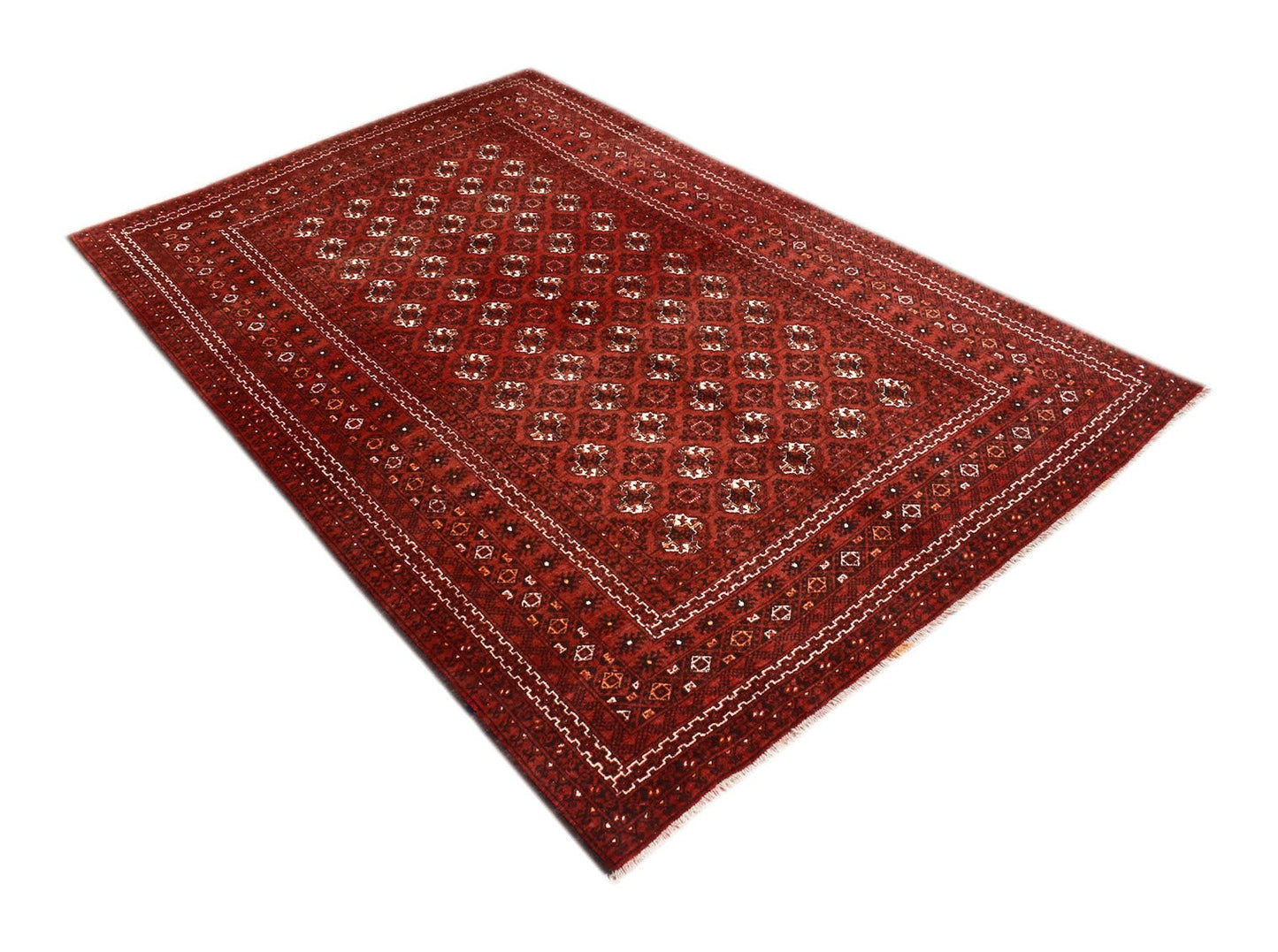 A vintage handmade Afghan Turkmen rug featuring a repeating geometric elephant foot motif in red.