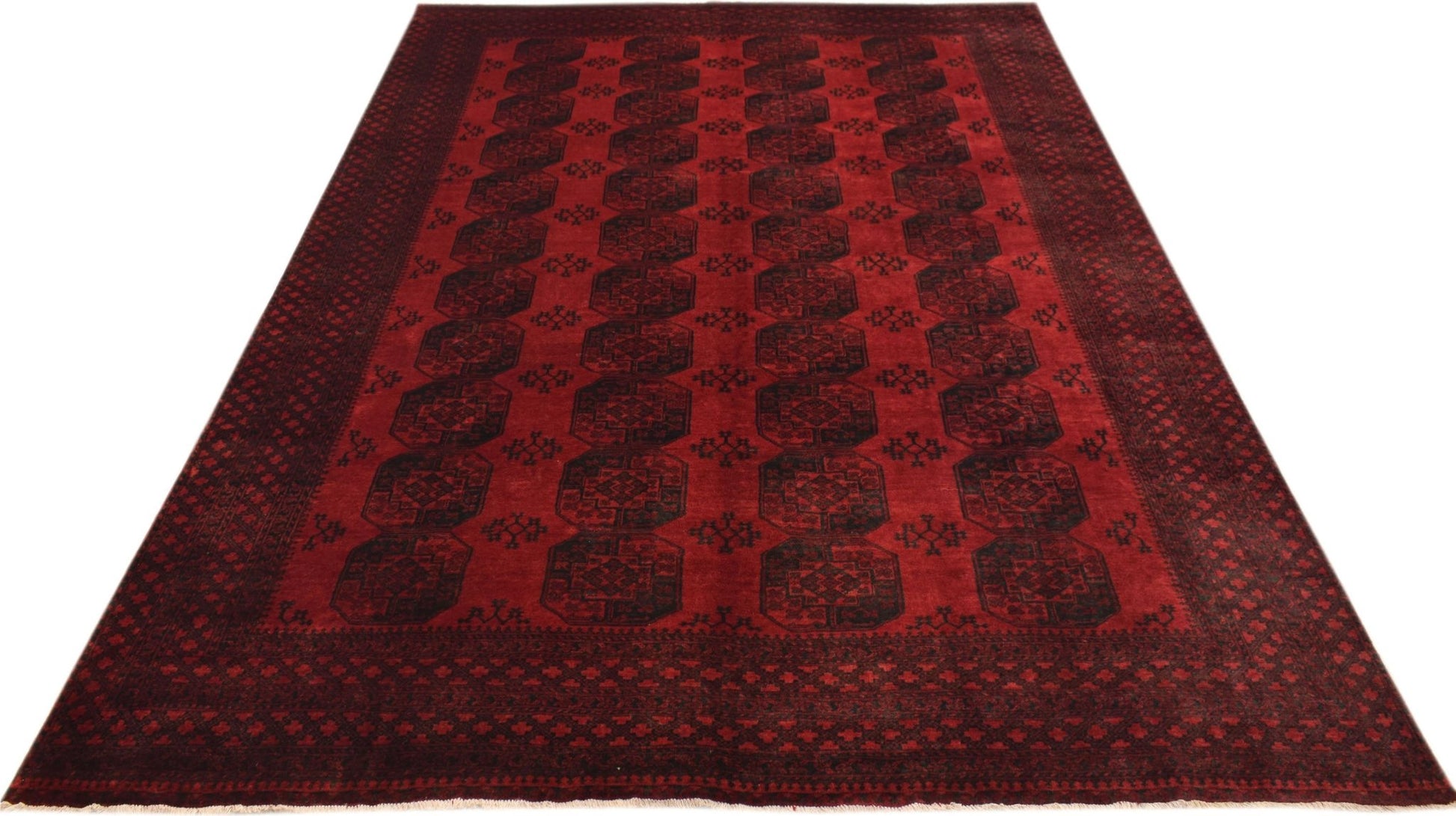 A vintage handmade Afghan Turkmen rug featuring a repeating dark red elephant foot motif.