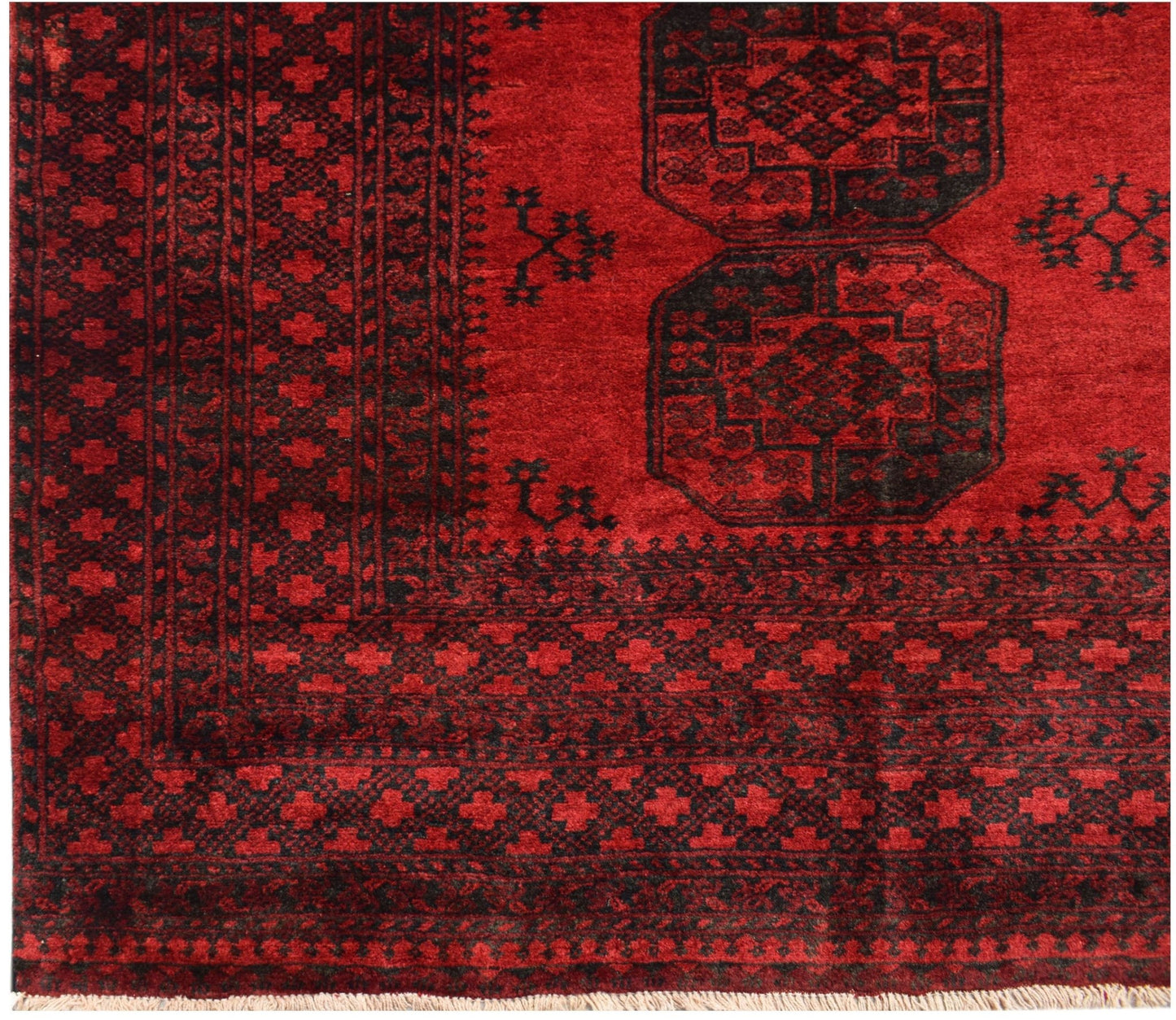 A vintage handmade Afghan Turkmen rug featuring a deep red field with black geometric motifs.
