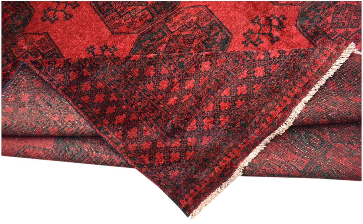 A vintage Afghan Turkmen rug featuring a red field with black geometric elephant foot motifs.