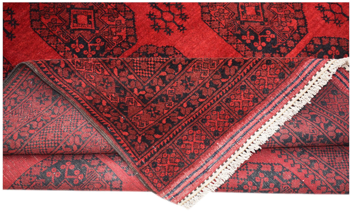 A vintage Afghan Turkmen rug featuring a red field with black geometric elephant foot motifs.