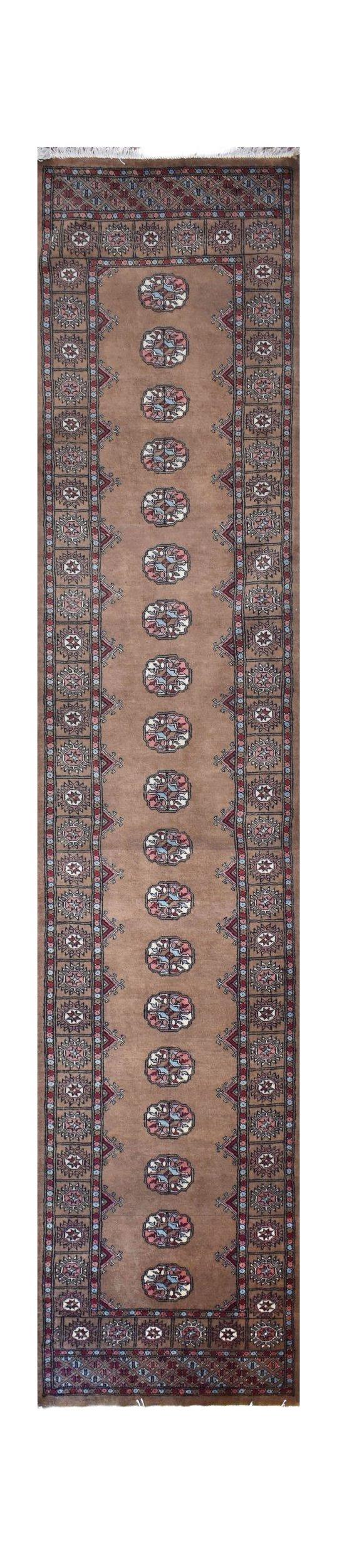 A handmade wool runner rug featuring a tan field with repeating geometric Bokhara motifs.