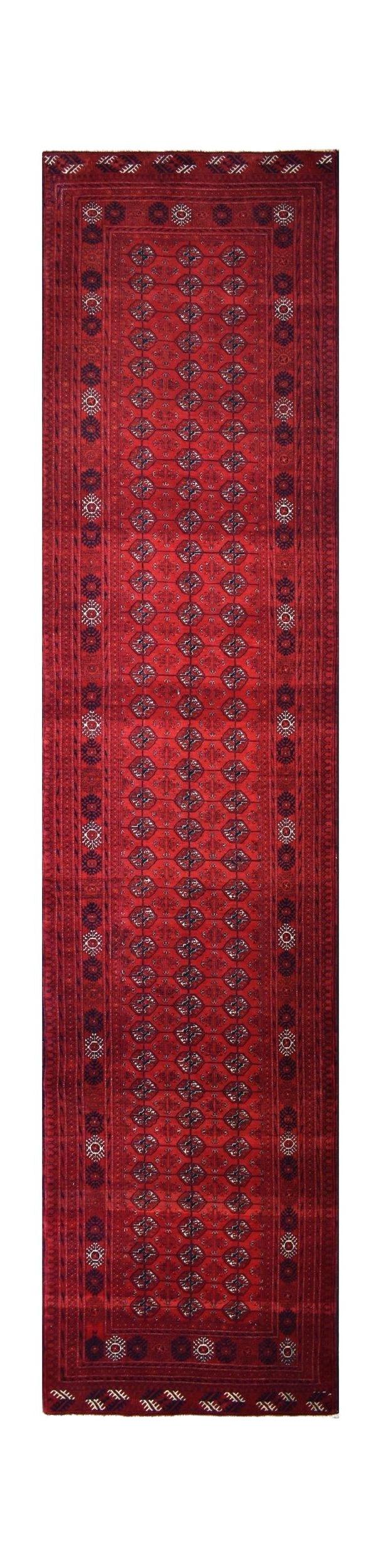 A vintage Afghan Turkmen runner rug featuring a repeating geometric pattern in deep red tones.