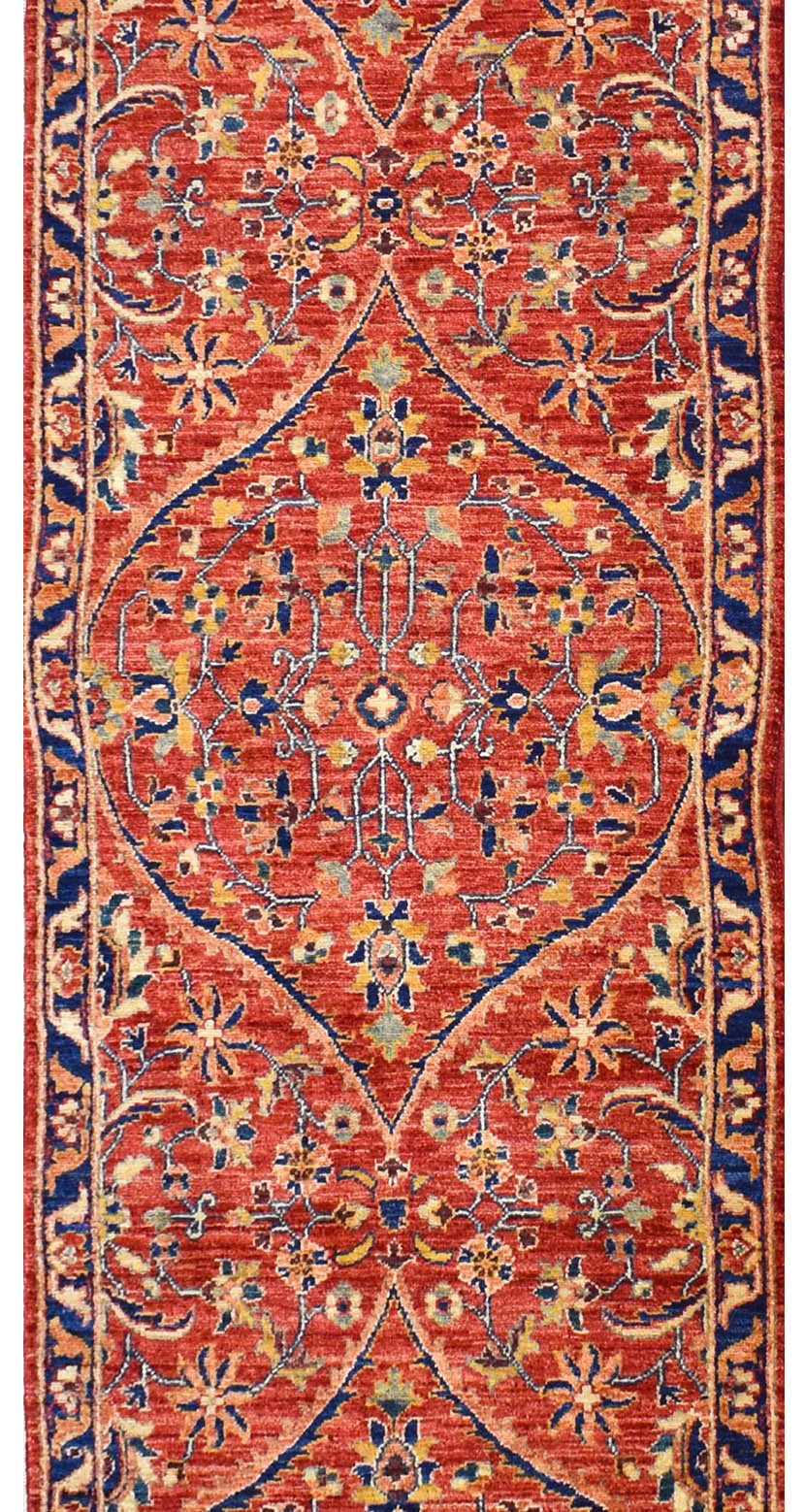 Handmade Afghan Chobi runner rug featuring a traditional floral medallion pattern in red and blue.