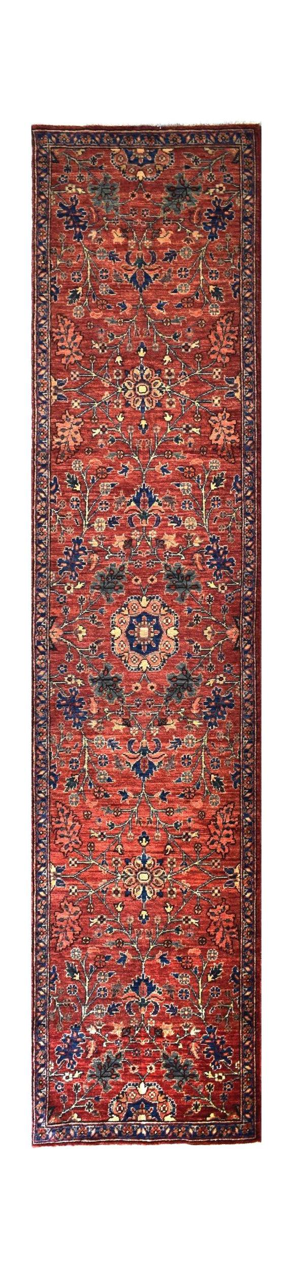 A handmade Afghan Chobi runner rug featuring a traditional floral pattern in red and blue tones.