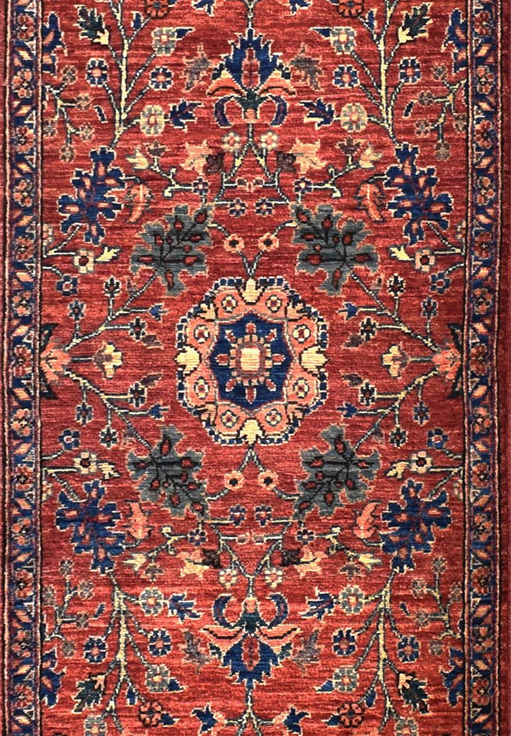 An Afghan Chobi runner featuring a traditional floral medallion pattern in red, blue, and cream.