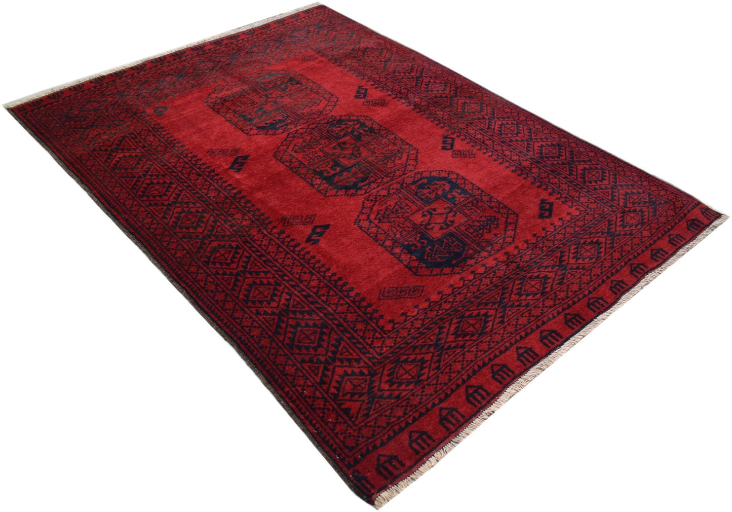 A handmade vintage Afghan Turkmen rug featuring a deep red field with repeating elephant foot motifs.