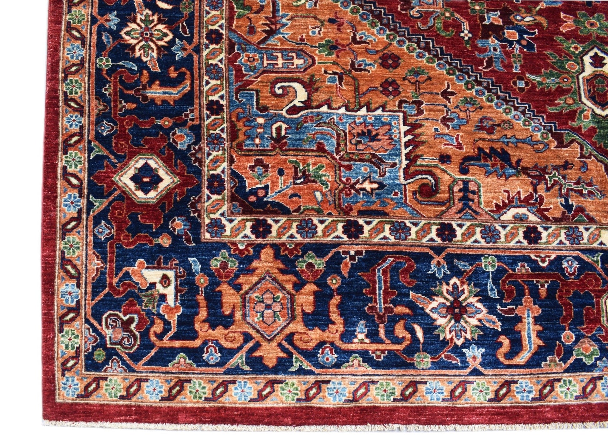 A handmade Afghan Chobi rug featuring a traditional Heriz pattern in deep blue, red, and orange.
