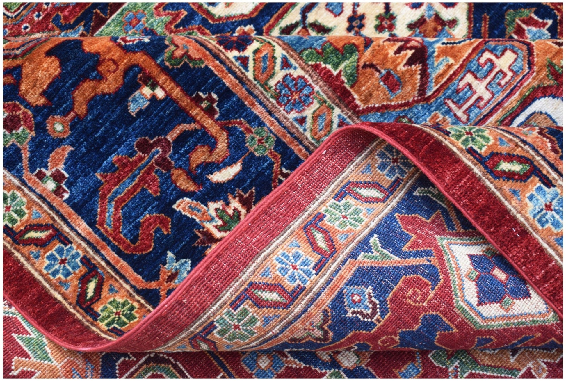 A handwoven Afghan Chobi rug featuring a traditional Heriz pattern in blue, red, and orange tones.