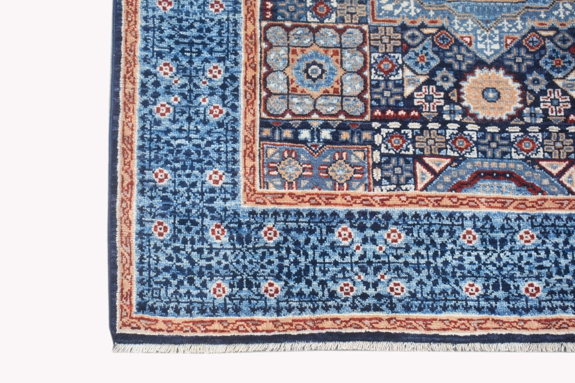 A handmade Afghan Chobi runner rug featuring a blue field with intricate geometric patterns.