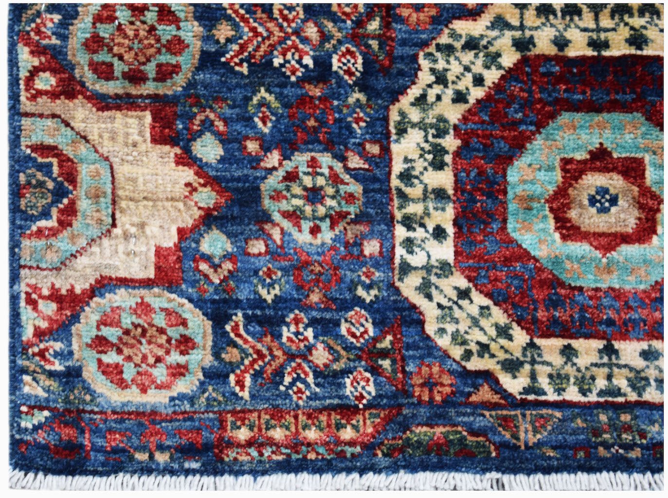 Handmade Afghan Chobi runner rug featuring a blue field with intricate red and teal medallions.