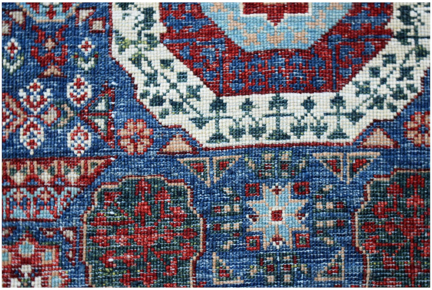 A close-up of a handmade Afghan Chobi runner featuring intricate blue and red Mamluk medallions.